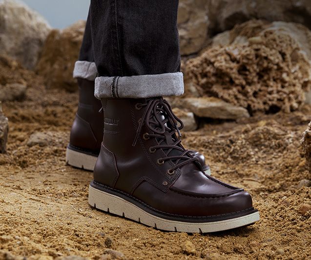 Les jambes d'une personne dans des bottes Covert marron.