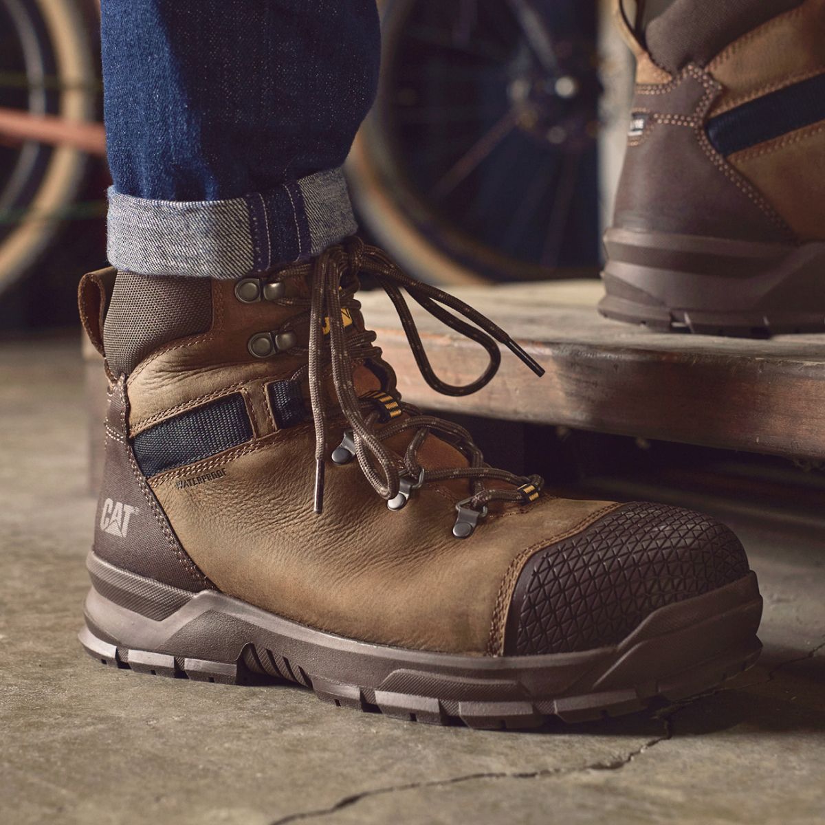 Brown boots stepping onto a wooden platform.