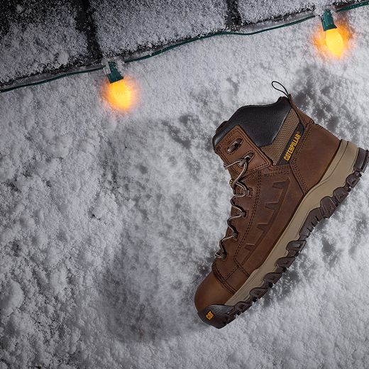 Boots in the snow, surrounded by holiday lights.