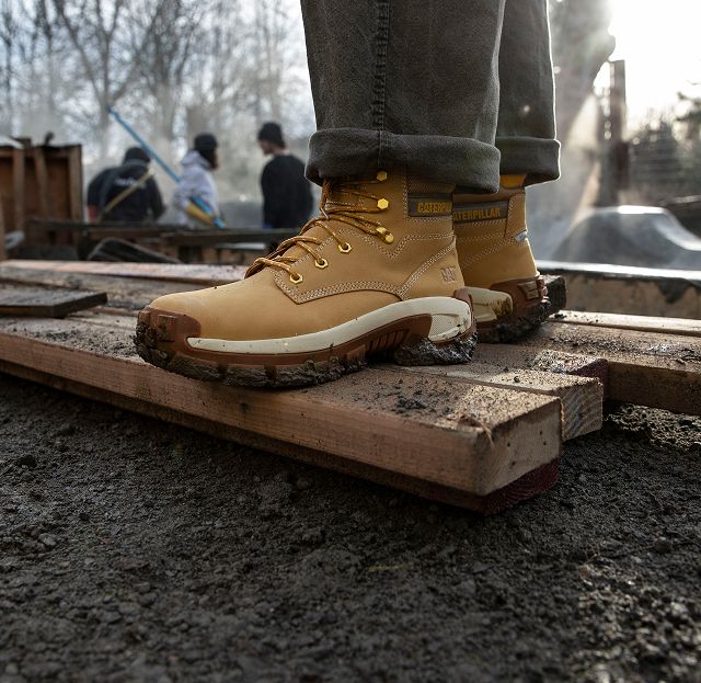 Boots standing on 2x4s in mud.