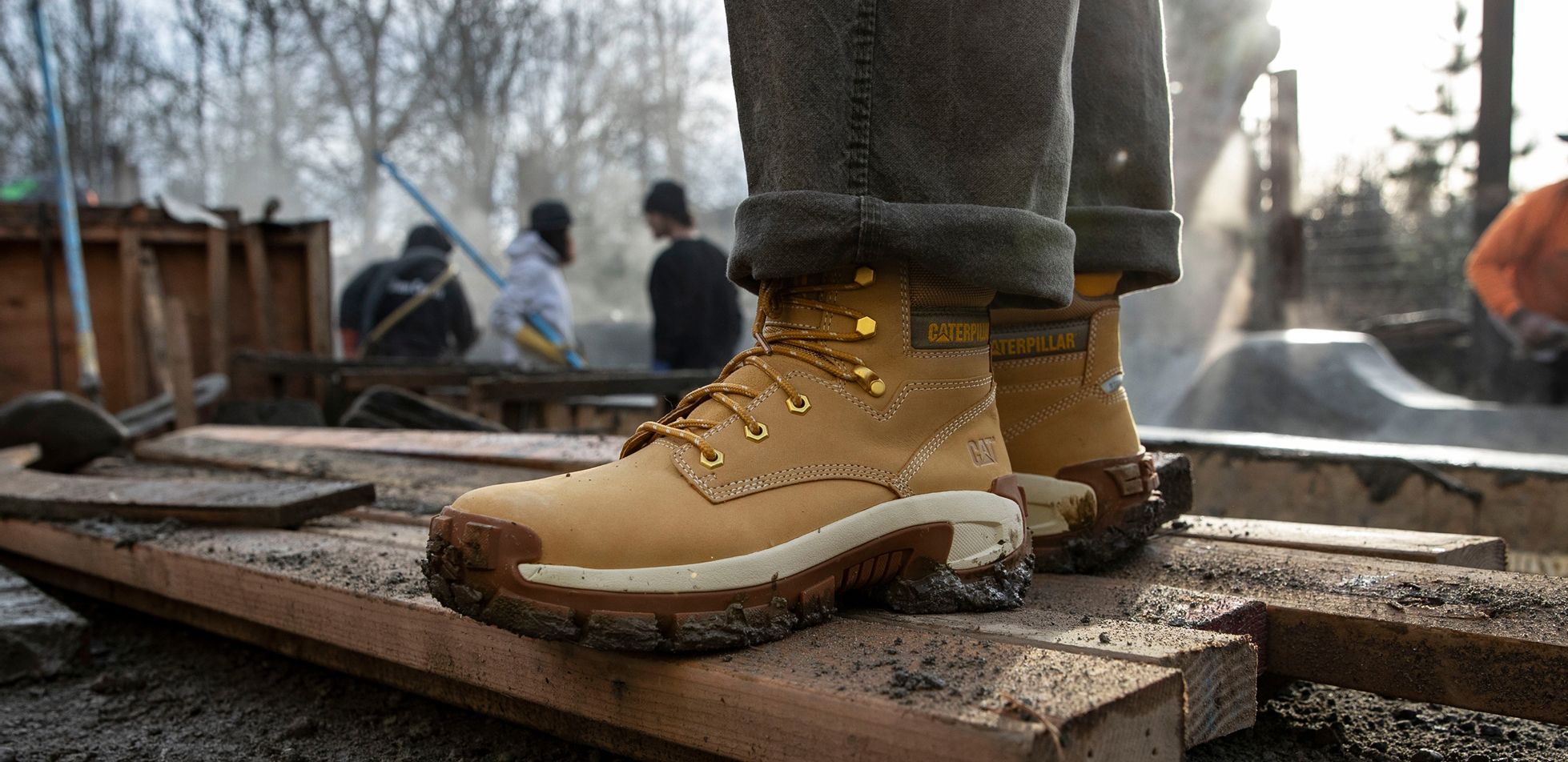 Boots standing on 2x4s in mud.