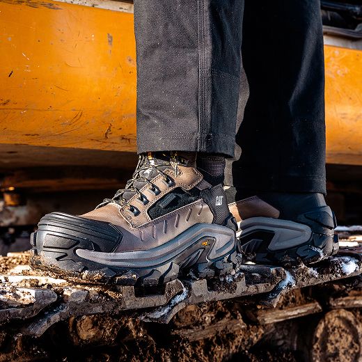 Boots standing on caterpillar tracks.