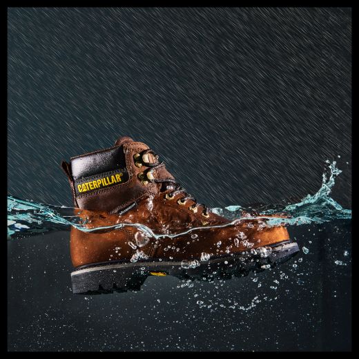 Brown boot with Wolverine logo semi-submerged in water.
