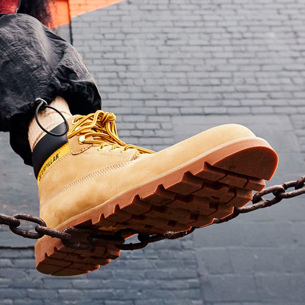 Tan Colorado Boot standing on a metal chain.