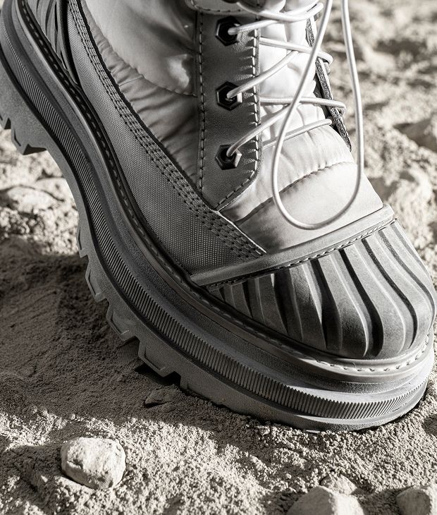 Light grey boot on a dusty lunar surface.