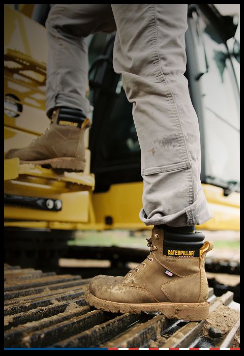 Brown & black boots standing on caterpillar tracks.