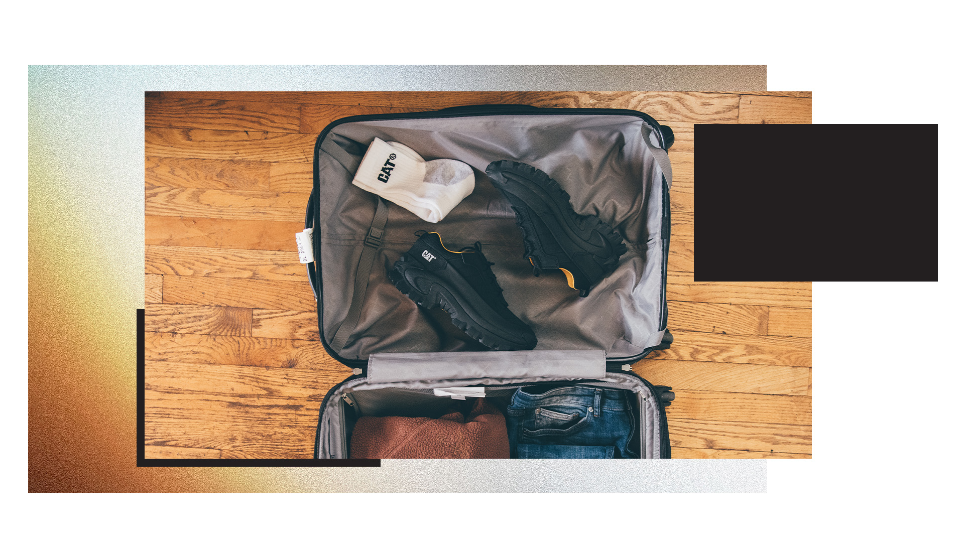 Open suitcase full of CAT clothing.