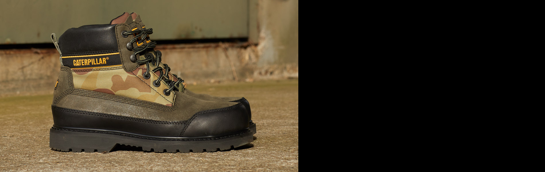 Tan work boot on sandy ground.