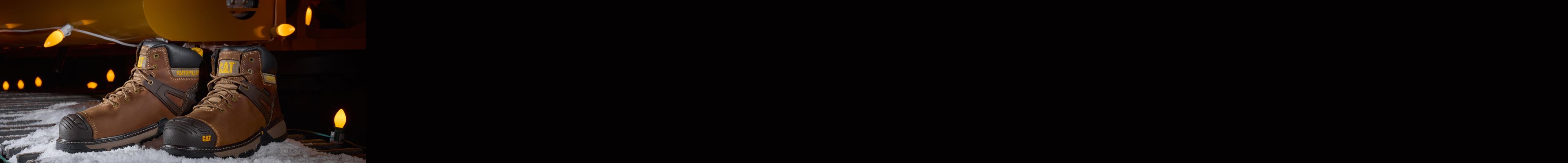 Boots in the snow, surrounded by holiday lights.