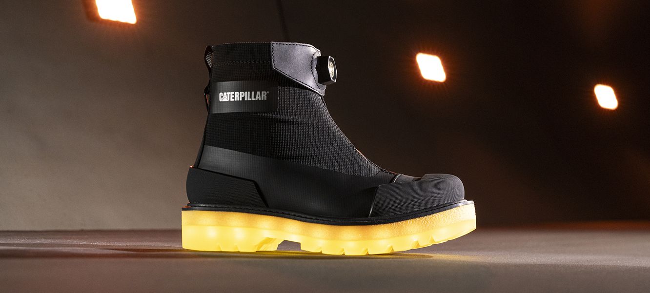 Black boot with yellow sole in front of a tunnel entrance.