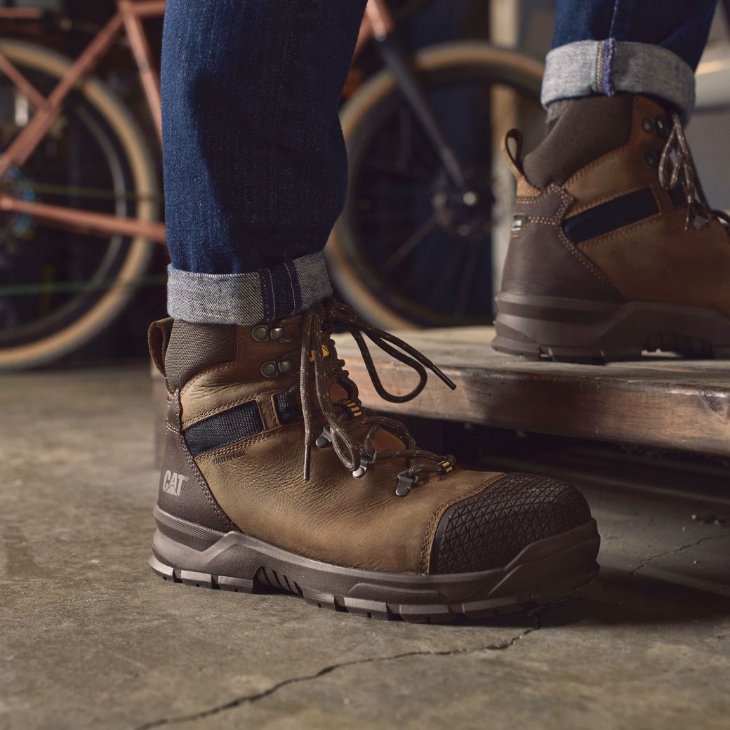Brown boots stepping onto a wooden platform.