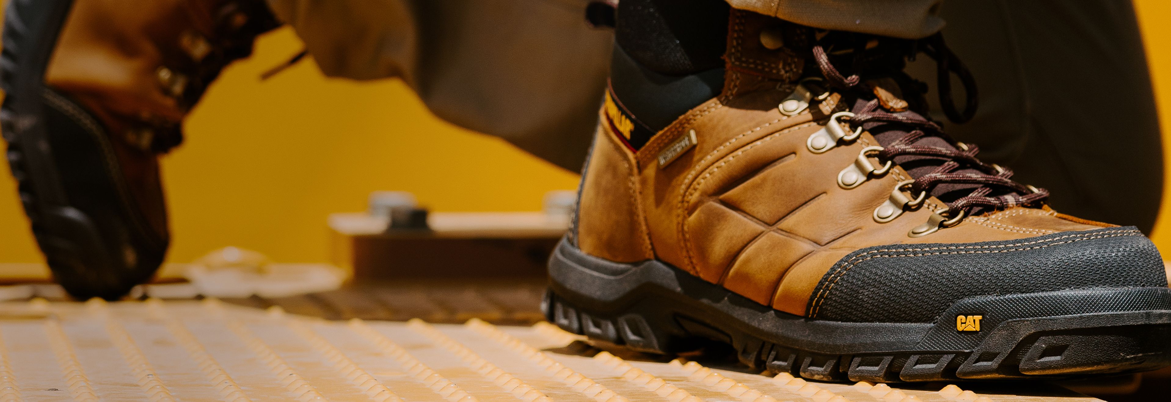 Brown boots worn by a crouching worker.