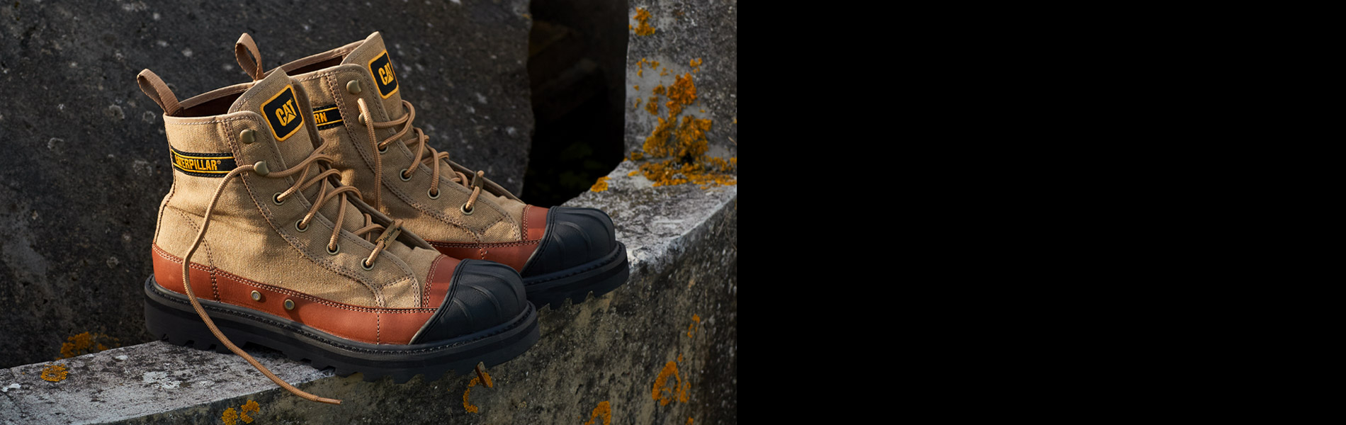 Tan work boot on sandy ground.