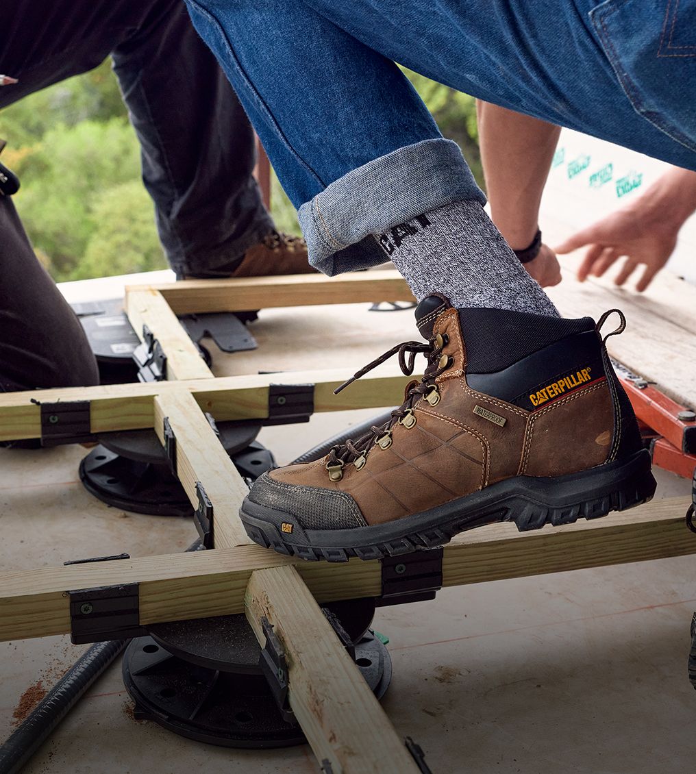 Boots standing on narrow wooden framing.