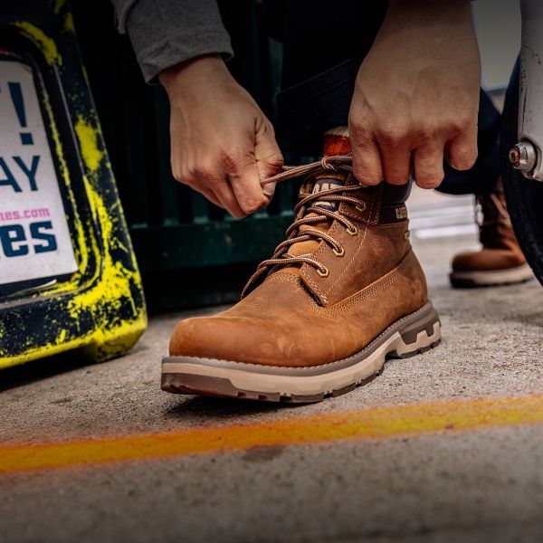 Tying the laces on brown boots.