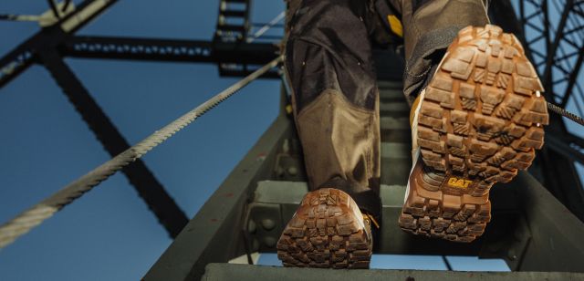 Looking up at boots walking down a steel staircase.