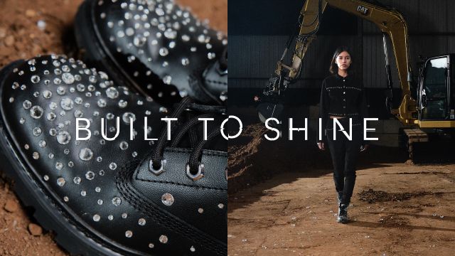 Standing in front of a excavator wearing black CAT boots encrusted with Svarovski crystals.
