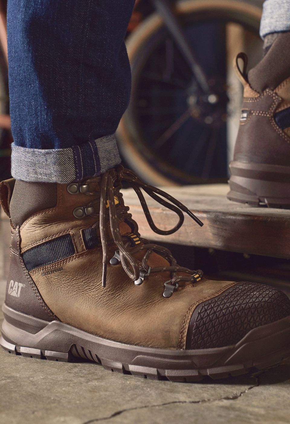 Brown boots stepping onto a wooden platform.