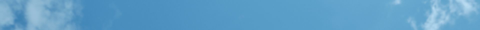 Bright blue sky with wispy white clouds.