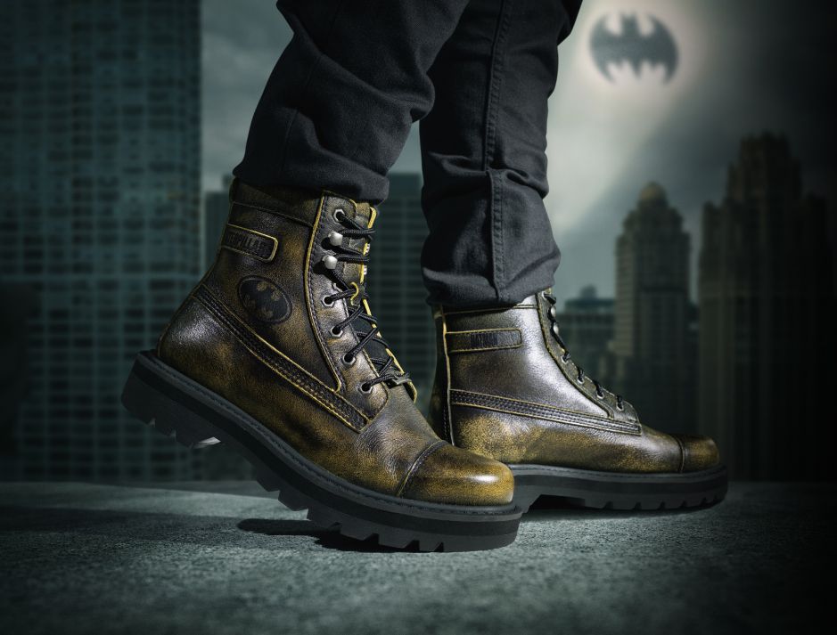 Green-black boots with Batman logo walking on a precarious city ledge.