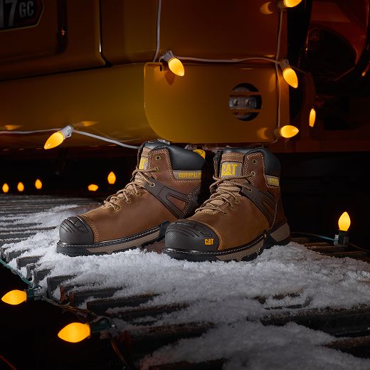Boots in the snow, surrounded by holiday lights.