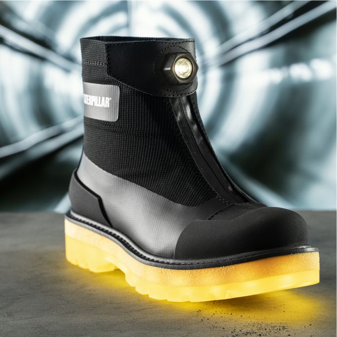 Boot in front of a tunnel entrance showing off headlight and illuminated sole.