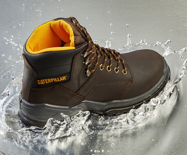 Brown Striver Waterproof Workboot with bright orange interior splashing in water.